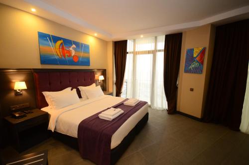 a hotel room with a bed with two towels on it at Batumi Palm Hotel in Batumi
