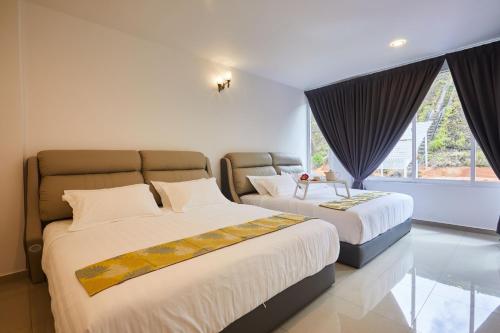 a bedroom with two beds and a window at Ahn-Yi Residence in Brinchang