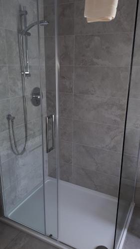 a shower with a glass door and a shower stall at Achintee Farm Guest House in Fort William