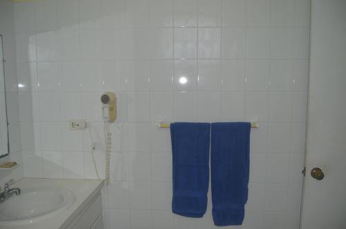 a bathroom with a sink and a blue towel at Surfers Manor Motel in Gregory Town