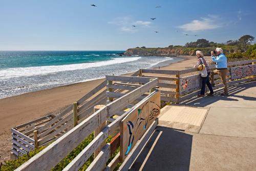 two people standing on a sidewalk near the beach at Cavalier Oceanfront Resort in San Simeon