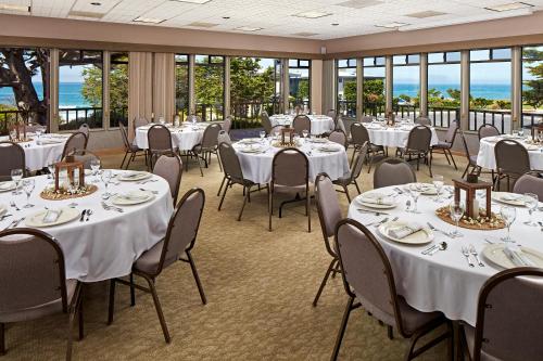a banquet room with tables and chairs and windows at Cavalier Oceanfront Resort in San Simeon