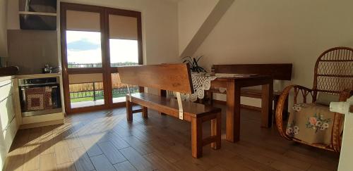 a kitchen with a wooden table and a table and chairs at Zagroda Jakubka in Myszyniec