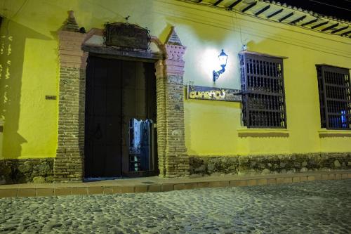 a yellow building with two windows and a street at Casa Hotel Guaracú in Santa Fe de Antioquia