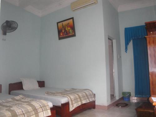a bedroom with two beds and a picture on the wall at Phuong Mai Family Hotel in Cat Ba