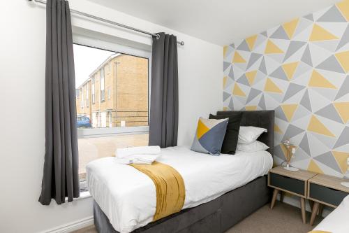 A bed or beds in a room at Hertford Serviced Apartments by Payman Club