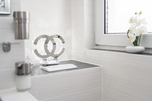 a white bathroom with a window and a vase of flowers at Ferienappartment Brigitte Güterglück in Güterglück