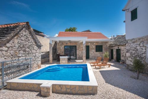 a swimming pool in front of a house at Villa Konoba Primošten With Heated Pool in Primošten