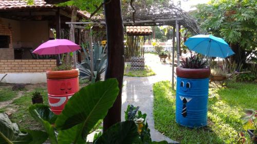 two colorful barrels with umbrellas in a garden at Pousada do Lajes in Carolina