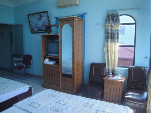 a bedroom with a bed and a mirror and a tv at Phuong Mai Family Hotel in Cat Ba