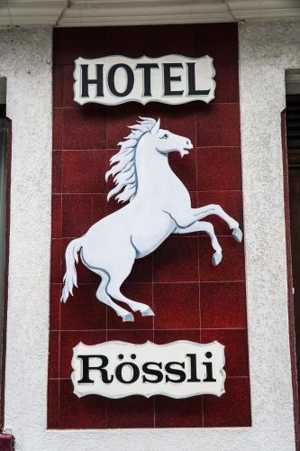 a sign for a hotel with a horse on it at Weisses Rössli in Leukerbad