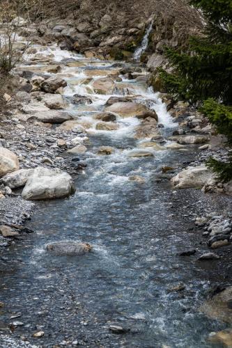a stream of water with rocks on a mountain at Weisses Rössli in Leukerbad
