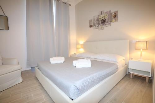 1 dormitorio blanco con 1 cama con 2 toallas en Unique luxury apartment and rooms, en Roma