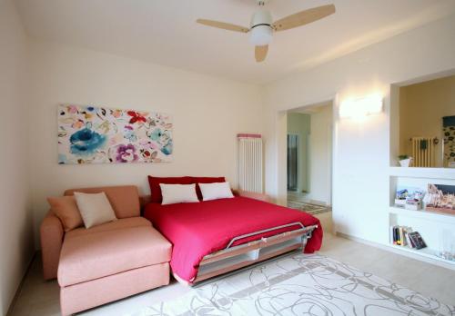 a bedroom with a pink bed and a couch at La Casa di Eva in Vittorio Veneto