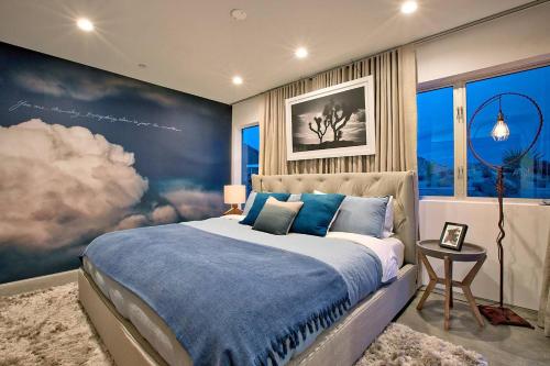 ein Schlafzimmer mit einem großen Bett mit einem Gemälde an der Wand in der Unterkunft SkyHouse in Joshua Tree