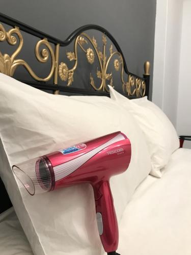 a red hairdryer is on the side of a bed at 玖拾捌民宿-98bnb in Hualien City