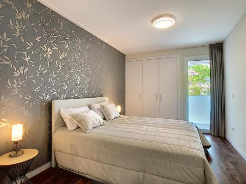 ein Schlafzimmer mit einem Bett mit floralen Akzenten in der Unterkunft Gardenia Apartment by LovelyStay in Funchal