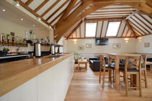 a kitchen and living room with a bar and a table at Neuadd Henllan Lodge in Builth Wells