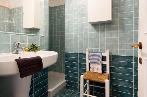 y baño con azulejos azules y lavabo. en Casa a 10m dal Mare, en Palau