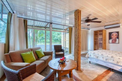 a living room with a couch and a bed at CariPro Apartments in Puerto Viejo