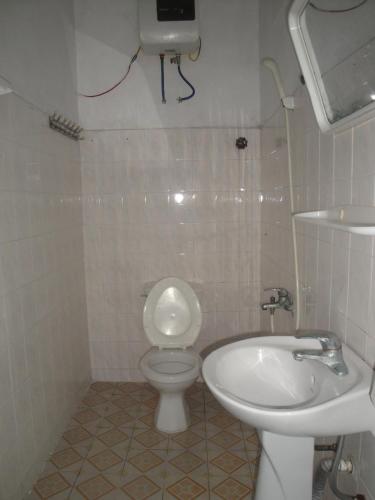 a white bathroom with a toilet and a sink at Phuong Mai Family Hotel in Cat Ba