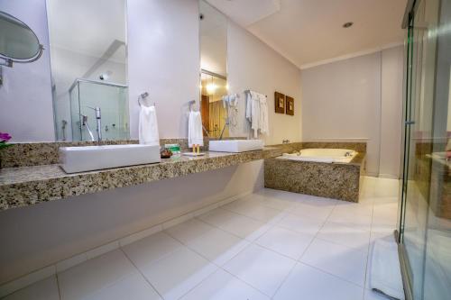 a large bathroom with two sinks and a shower at Hotel Porto Madeira in Porto Velho