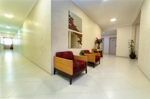 a corridor of a hospital with chairs and flowers at Hotel Porto Madeira in Porto Velho