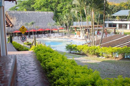a resort with a swimming pool with tables and chairs at Hosteria Guaracú in San Jerónimo