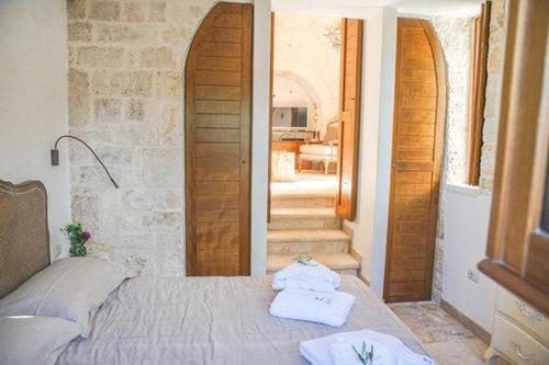 sypialnia z łóżkiem i dwoma ręcznikami na nim w obiekcie Trullo Grace -Trulli Anti' Charme & Relax w Alberobello