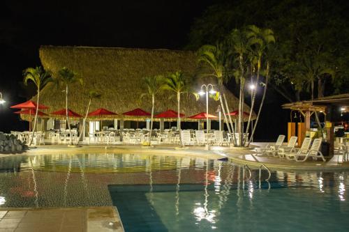 a pool with chairs and umbrellas at night at Hosteria Guaracú in San Jerónimo