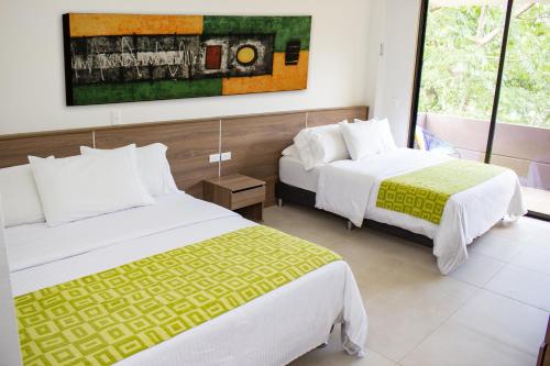 a hotel room with two beds and a painting on the wall at Hosteria Guaracú in San Jerónimo