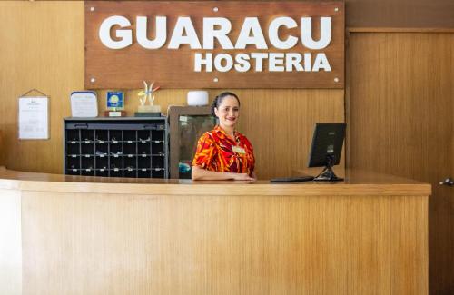 a woman standing behind a counter in a guatemala hospital at Hosteria Guaracú in San Jerónimo