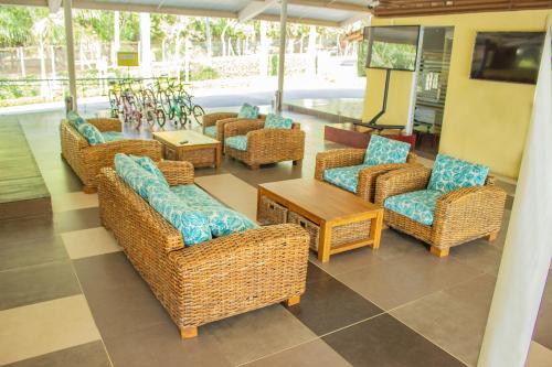 a group of wicker chairs and tables in a room at Hosteria Guaracú in San Jerónimo