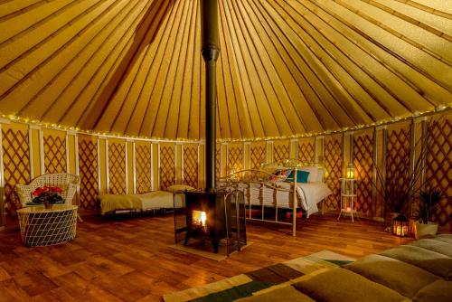 a room with a tent with a bed and a fireplace at Loughcrew Glamping in Oldcastle