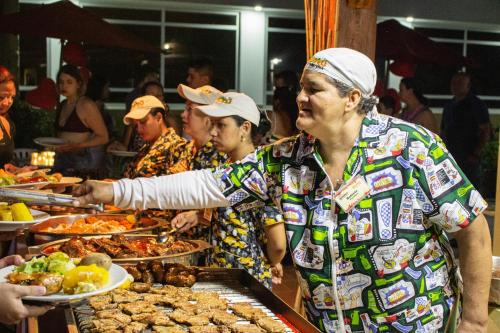 a woman reaching for a plate of food at a buffet at Hosteria Guaracú in San Jerónimo