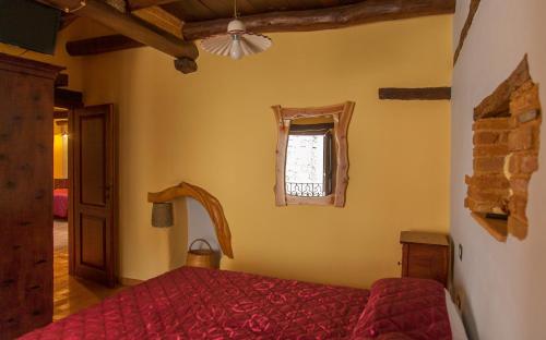 a bedroom with a red bed and a window at Antico Restauro in Fonni