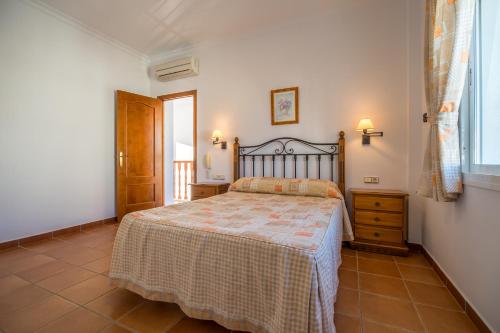 een slaapkamer met een bed, een ladekast en een raam bij Chalet adosado Atalaya F in Conil de la Frontera