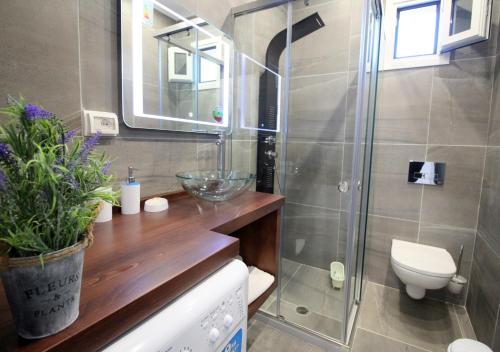 a bathroom with a shower with a toilet and a sink at Le Gjero luxury villa in Ksamil