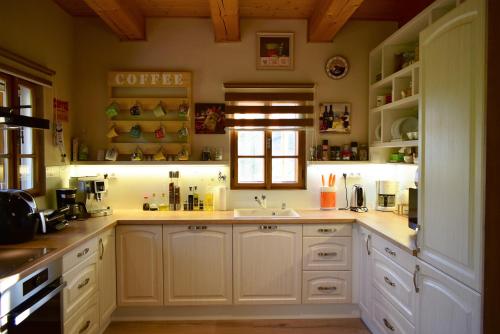 a kitchen with white cabinets and a sink and a window at Villa Harta in Vrchlabí