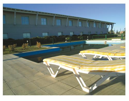two lounge chairs sitting next to a swimming pool at Elegance Hotel in Tres Arroyos