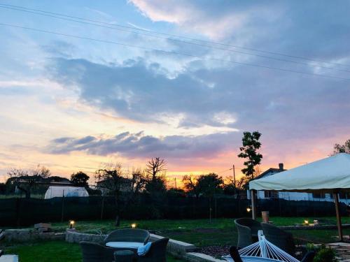 una puesta de sol en un patio con sillas y una tienda de campaña en Agriturismo Quercetelli, en Castiglione del Lago