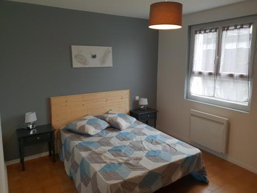 - une chambre avec un lit, une fenêtre et un couvre-lit dans l'établissement Appartement T2, à Lau-Balagnas