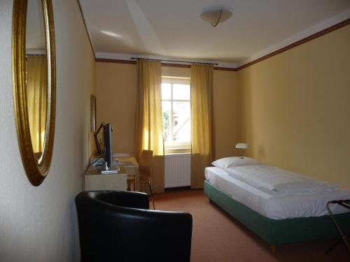 a hotel room with a bed and a window at Zur Alten Schmiede in Naumburg