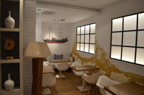a restaurant with chairs and a table andwindows at Hotel Rastoni - Helvetia in Platamonas