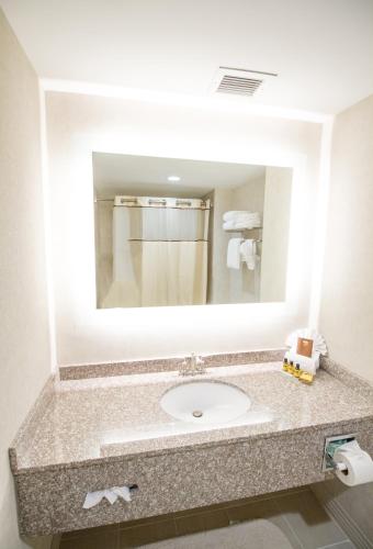 a bathroom with a sink and a large mirror at Best Western Plus Fairfield Executive Inn in Fairfield