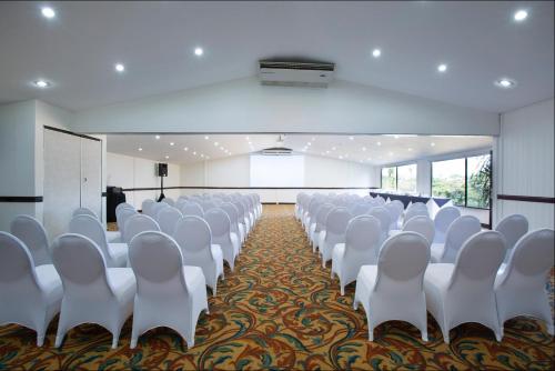 a conference room with white chairs and a podium at Country Inn & Suites by Radisson, San Jose Aeropuerto, Costa Rica in San José