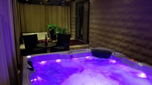 a purple bath tub in a room with a table at Villa Summer dream with heated pool, sauna and jacuzzi in Malinska