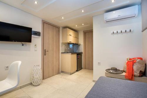 a room with a kitchen with a tv on the wall at Estian Deluxe in Limenaria