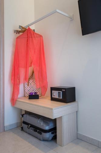 a table with a microwave on a shelf in a room at Estian Deluxe in Limenaria