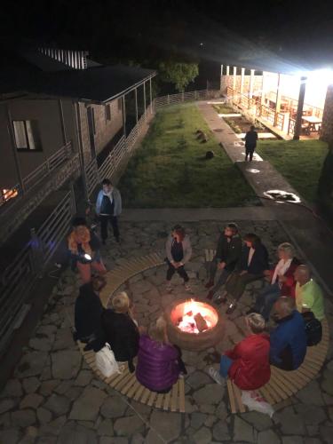 a group of people sitting around a fire in a courtyard at Lara Hotel in Goris